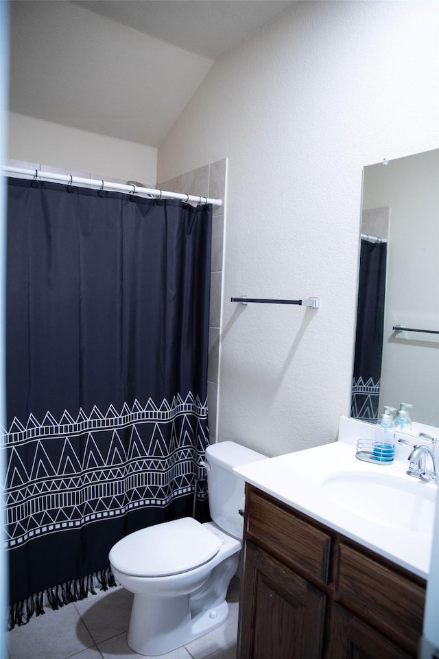 bathroom featuring tile patterned flooring, vanity, lofted ceiling, and toilet