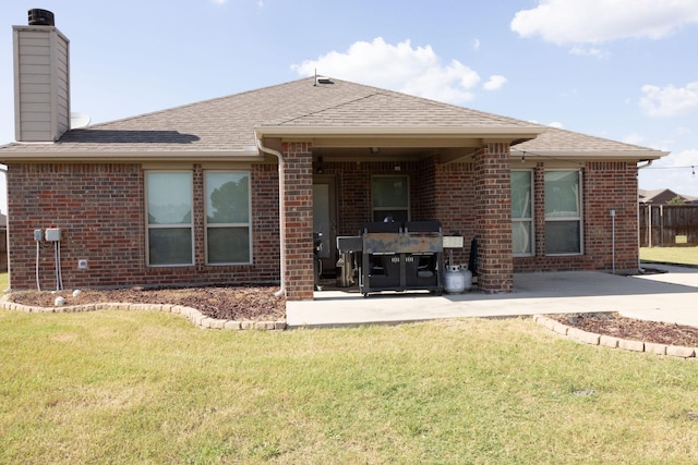 rear view of property featuring a patio and a lawn