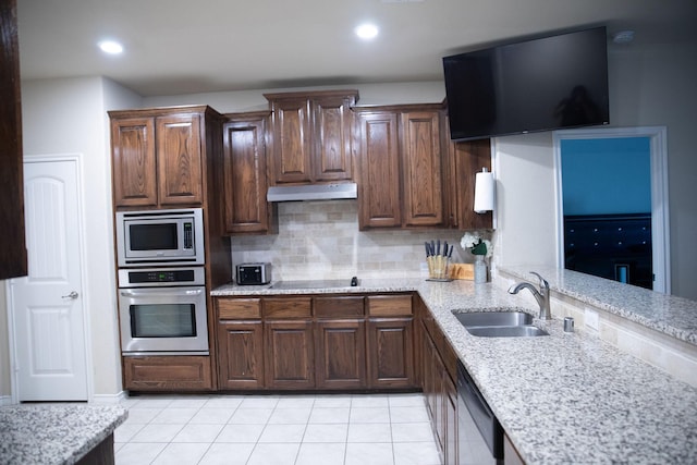 kitchen featuring sink, stainless steel appliances, dark brown cabinetry, light tile patterned flooring, and decorative backsplash