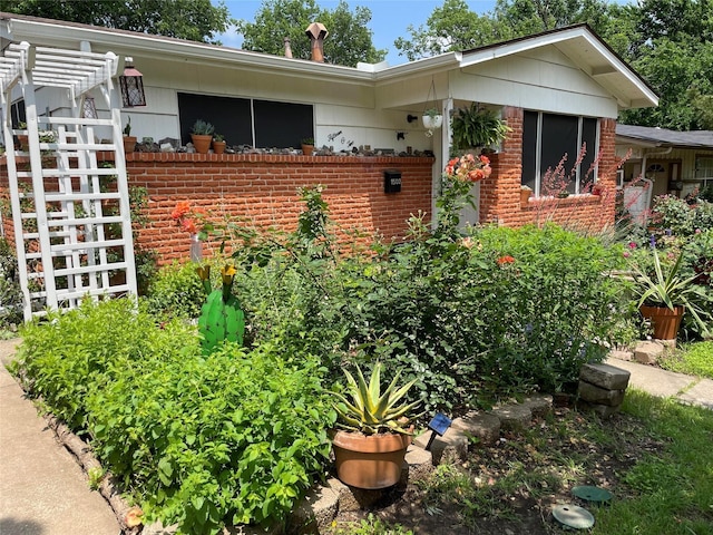 exterior space with a pergola and brick siding