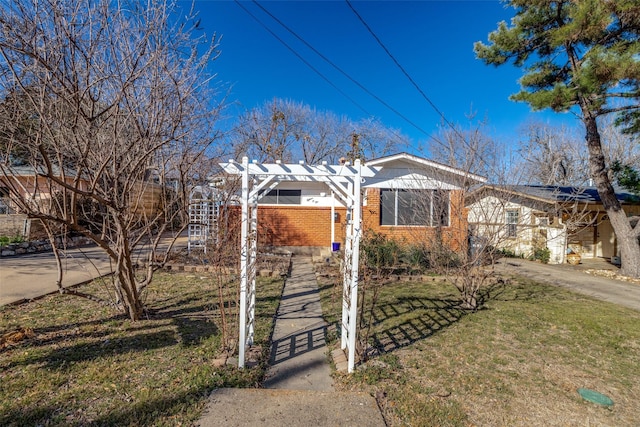 view of front of home featuring brick siding and a front lawn