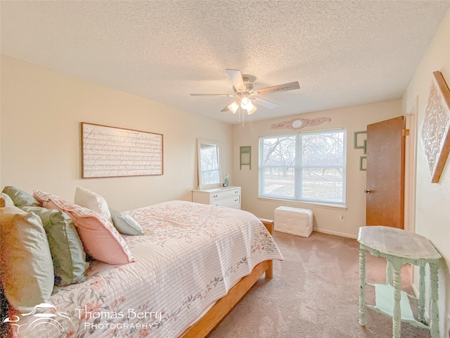 carpeted bedroom featuring multiple windows, a textured ceiling, and ceiling fan