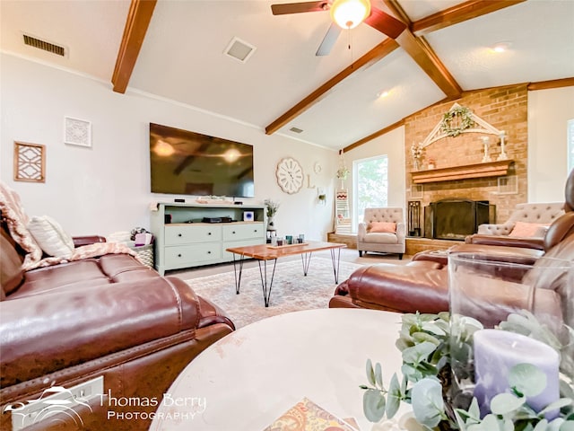 living room featuring a brick fireplace, vaulted ceiling with beams, and ceiling fan