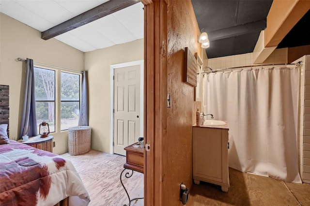 bedroom with lofted ceiling with beams, sink, and light hardwood / wood-style floors