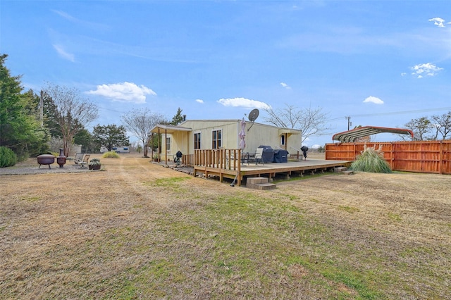 view of yard with a deck and an outdoor fire pit