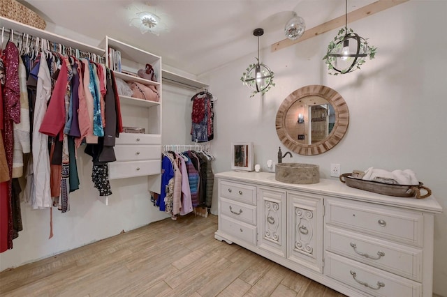 spacious closet with sink and light hardwood / wood-style flooring