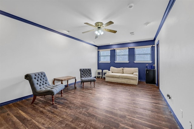 living area featuring dark wood-type flooring, ceiling fan, and ornamental molding