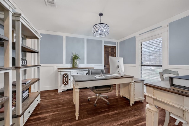 home office with dark hardwood / wood-style flooring and a chandelier