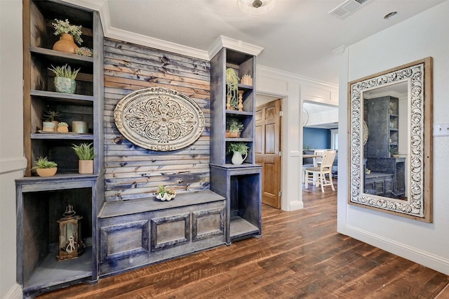 interior space featuring ornamental molding, dark hardwood / wood-style flooring, and built in shelves