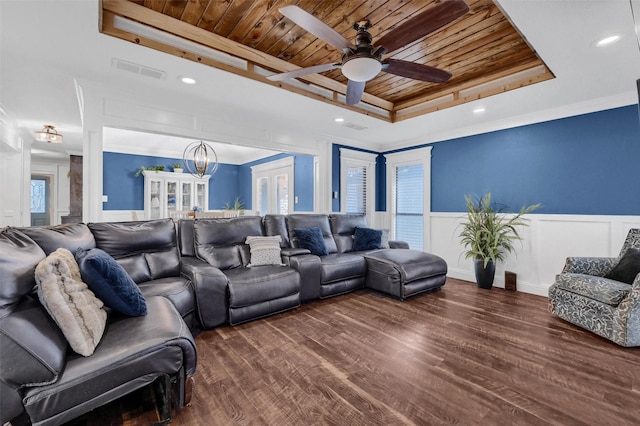 living room featuring hardwood / wood-style flooring, a tray ceiling, ornamental molding, ceiling fan with notable chandelier, and wooden ceiling