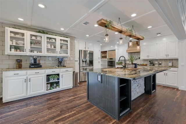 kitchen featuring white cabinetry, a large island, light stone counters, stainless steel appliances, and dark wood-type flooring