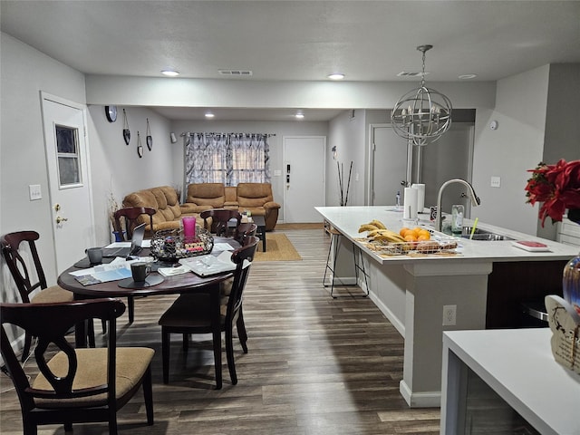 dining space featuring dark wood-style floors, a chandelier, baseboards, and recessed lighting