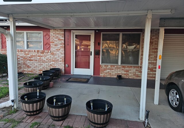 doorway to property featuring brick siding