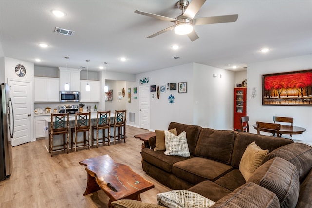 living room featuring ceiling fan and light hardwood / wood-style flooring