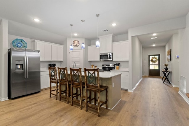2313 Atlantic Ave, Anna, TX 75409 - kitchen with stainless steel appliances, light wood-style floors, a kitchen breakfast bar, light countertops, and a center island with sink