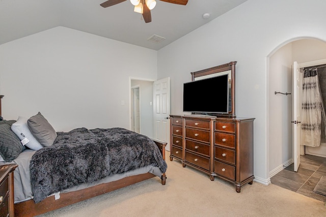 bedroom with vaulted ceiling, light colored carpet, and ceiling fan