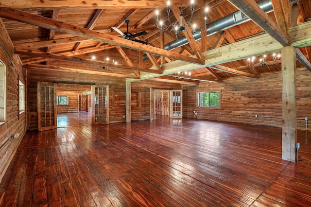 unfurnished room featuring lofted ceiling with beams, hardwood / wood-style flooring, wooden ceiling, and wooden walls