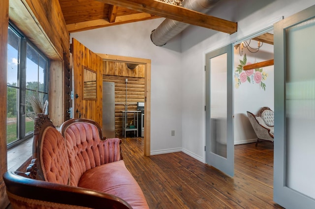 sitting room featuring dark wood-type flooring and vaulted ceiling with beams