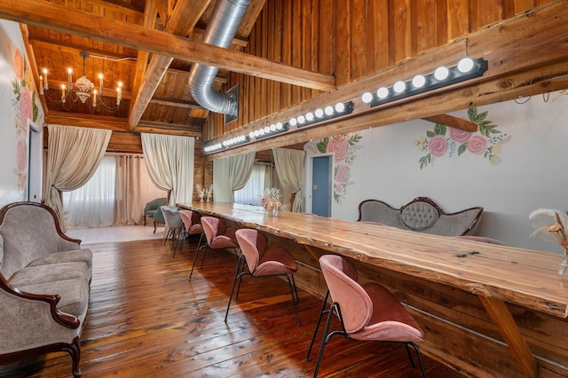 dining area featuring wood ceiling, wooden walls, wood-type flooring, and beam ceiling