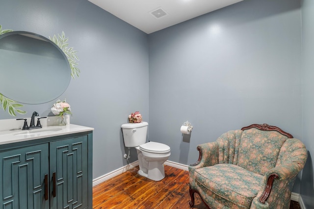 bathroom featuring wood-type flooring, toilet, and vanity