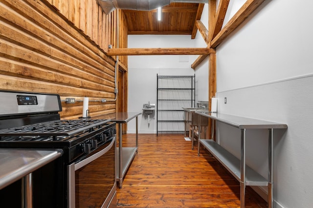 kitchen featuring wooden walls, dark hardwood / wood-style flooring, stainless steel range with gas cooktop, wooden ceiling, and beamed ceiling