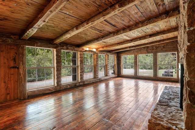 unfurnished sunroom with beamed ceiling and wood ceiling