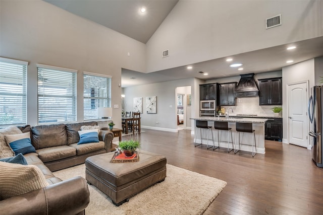 living room featuring dark hardwood / wood-style flooring and high vaulted ceiling