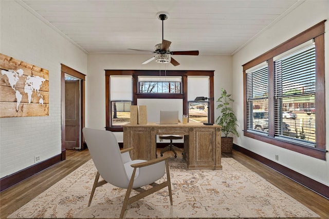 home office with dark wood-type flooring, ornamental molding, and plenty of natural light