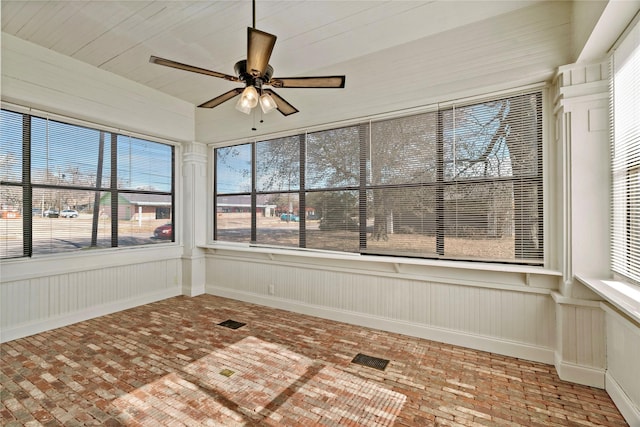 unfurnished sunroom with ceiling fan