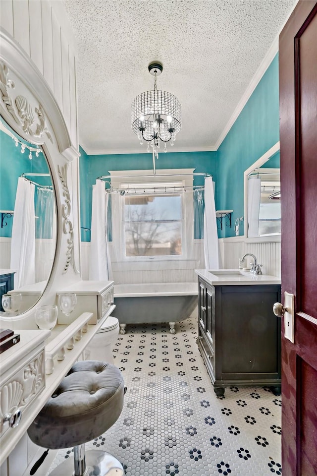 bathroom featuring plenty of natural light, toilet, a washtub, and a notable chandelier