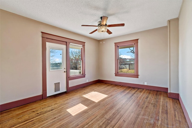 unfurnished room with ceiling fan, plenty of natural light, a textured ceiling, and light hardwood / wood-style floors