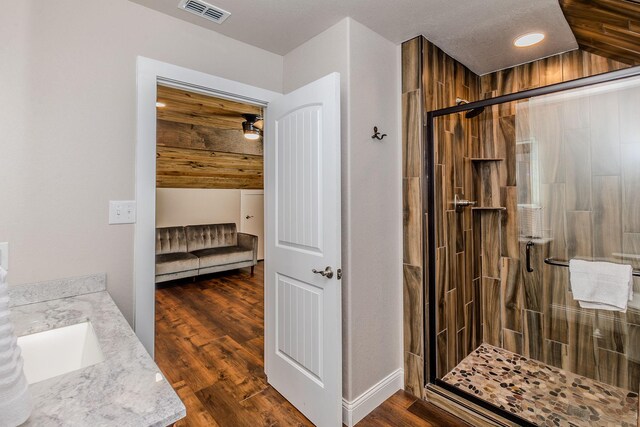 bathroom featuring vanity, hardwood / wood-style flooring, wooden ceiling, and walk in shower