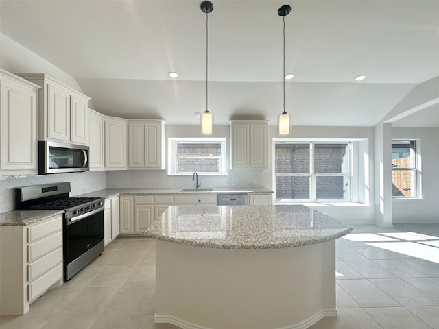 kitchen with lofted ceiling, white cabinetry, stainless steel appliances, light stone countertops, and decorative backsplash