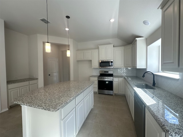 kitchen featuring tasteful backsplash, sink, white cabinets, a center island, and stainless steel appliances