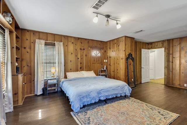 bedroom featuring dark hardwood / wood-style floors and wood walls