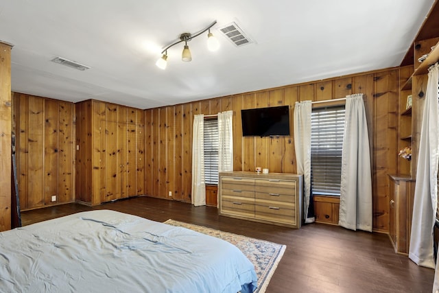 bedroom featuring wooden walls and dark hardwood / wood-style floors