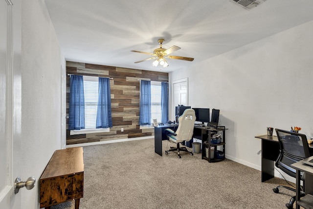 office space featuring ceiling fan, carpet flooring, and wooden walls