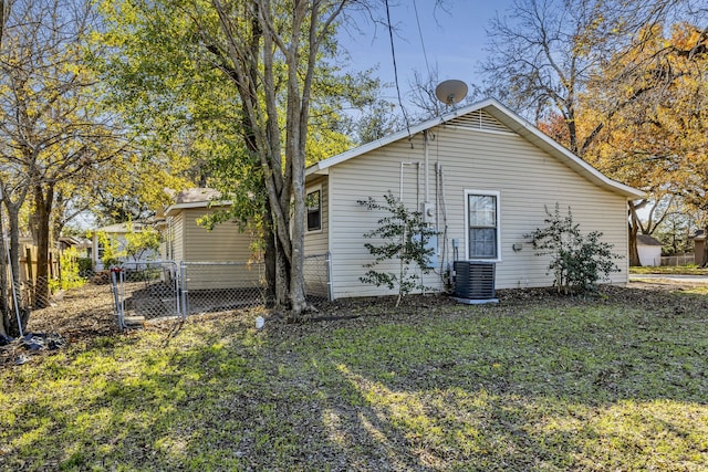 rear view of property featuring a yard and central AC