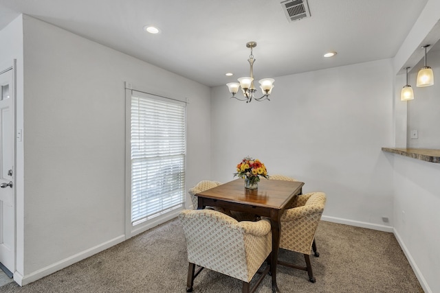 carpeted dining area featuring an inviting chandelier