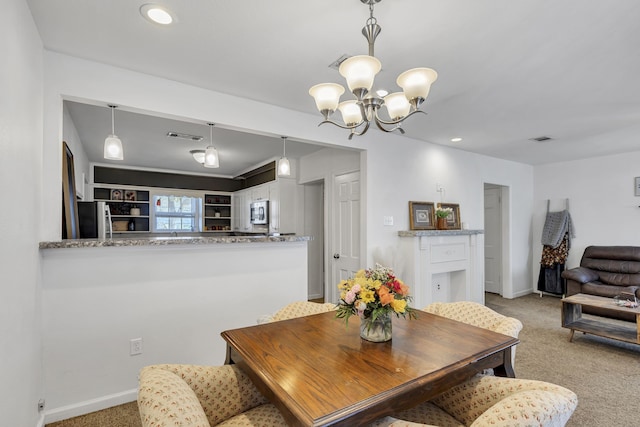 carpeted dining room with a chandelier