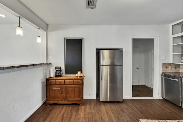 kitchen featuring stainless steel appliances, dark wood-type flooring, and decorative light fixtures