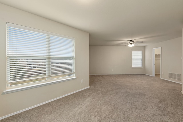 carpeted spare room featuring ceiling fan