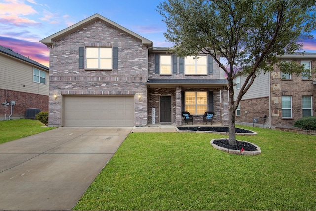 traditional-style home featuring a garage, brick siding, a yard, and driveway