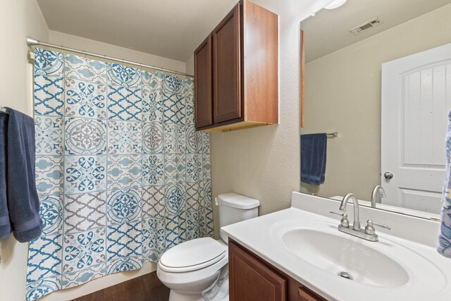 full bath featuring toilet, visible vents, a shower with shower curtain, and vanity