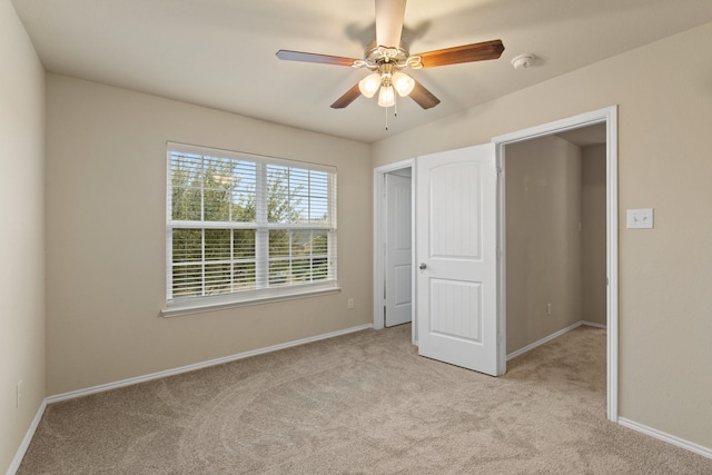 unfurnished bedroom featuring light colored carpet and ceiling fan