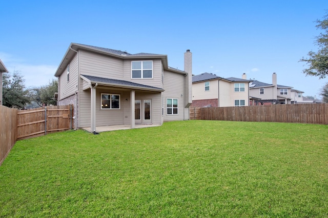 rear view of house featuring a patio area, a fenced backyard, and a lawn