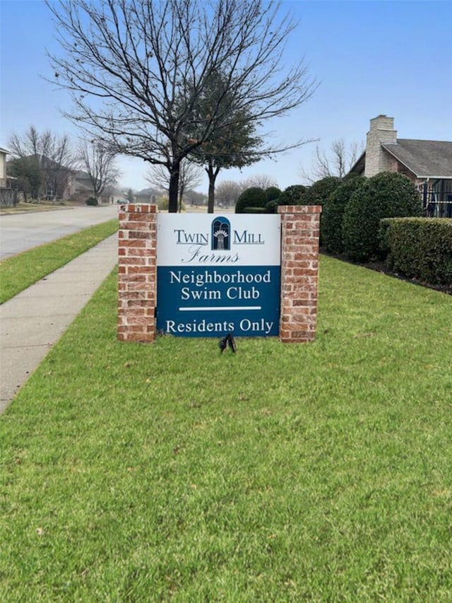 community / neighborhood sign with a yard