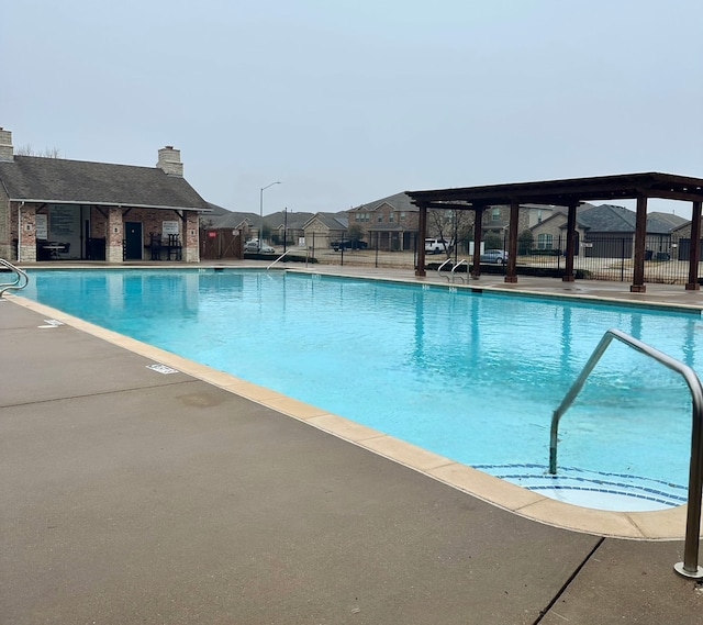 community pool featuring a patio area and fence