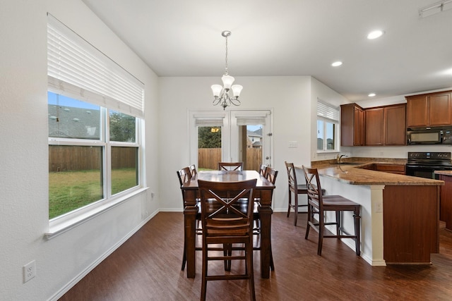 dining area featuring a notable chandelier, sink, and dark hardwood / wood-style floors