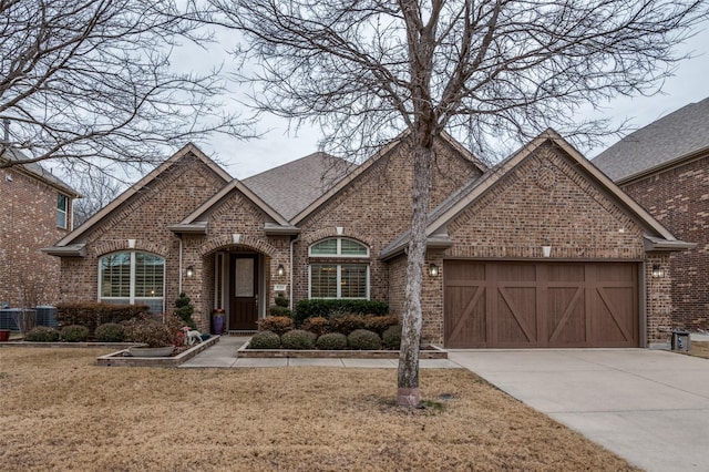 view of front of property featuring a garage, a front yard, and central air condition unit